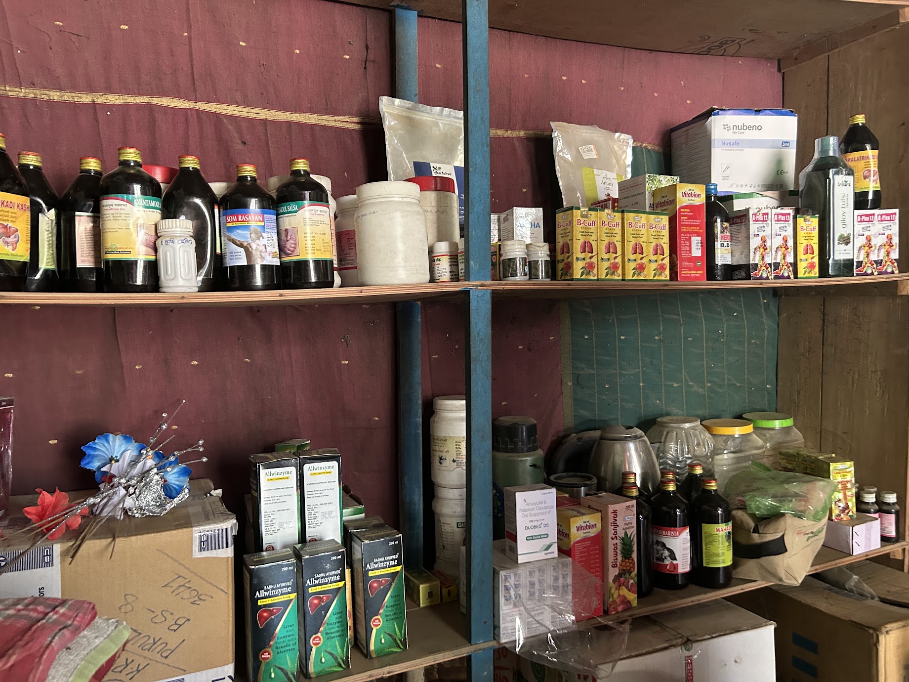 Medicine bottles, boxes and packets on wooden shelves in Jiling, West Bengal